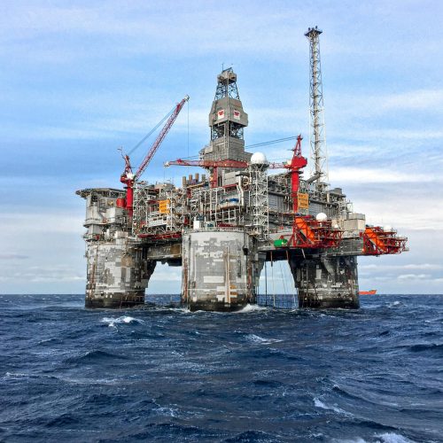 An offshore oil platform in Norway's North Sea under a clear blue sky.